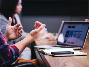 people working together in a meeting room with a laptop at the desk