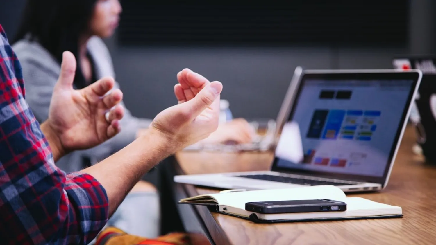 people working together in a meeting room with a laptop at the desk